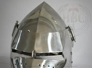 A polished steel medieval knight helmet with a pointed conical crown, visor, and side guards, shown against a light gray background with a faint HBC watermark.