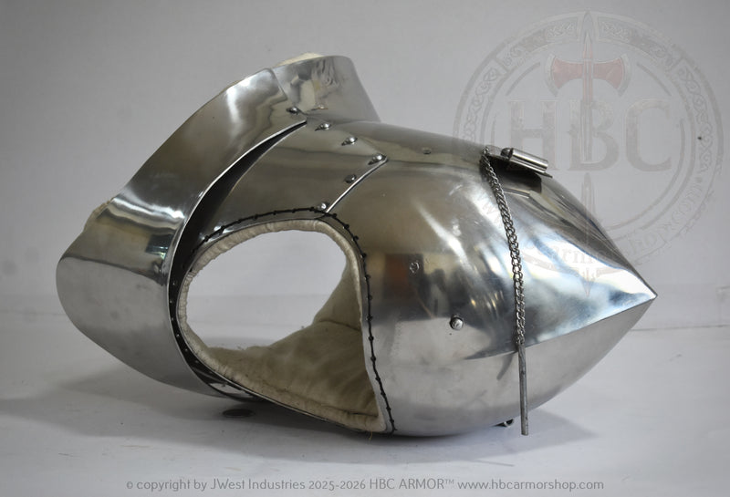 A polished steel medieval-style helmet or visor with a pointed tip, rivets, and a chain detail, photographed on a light gray background with a faint HBC Armor watermark.