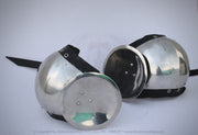 Two polished steel medieval round helmets with black padded undercaps and straps, displayed on a light gray background.