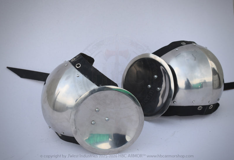 Two polished steel medieval round helmets with black padded undercaps and straps, displayed on a light gray background.
