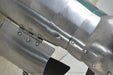 Close-up of a metallic armor plate or cannon plate with rivets and a hinge, showing a brushed silver steel finish.